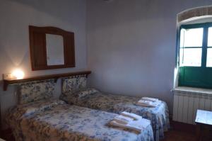 ein Hotelzimmer mit 2 Betten und Handtüchern darauf in der Unterkunft Studio für 4 Personen ca 60 qm in Monteriggioni, Toskana Chianti in Monteriggioni
