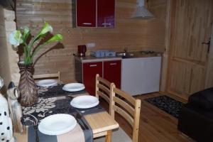 uma cozinha com uma mesa e cadeiras e uma cozinha com uma mesa e uma mesa em Ferienhaus Onyx em Mielno