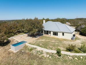 an aerial view of a white house with a swimming pool at Hill Country Norwood House- 13 Acres, Private Pool and Pet Friendly! in Dripping Springs