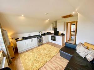 un soggiorno con divano e una cucina di Brohar Annexe a Inverness
