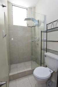 uma casa de banho com uma cabina de duche em vidro e um WC. em JudyHouse em Salinas