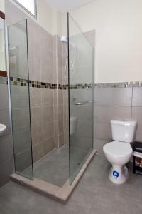 een badkamer met een toilet en een glazen douche bij JudyHouse in Salinas