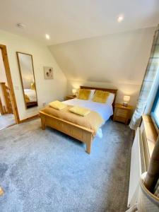 una camera con un grande letto e uno specchio di Brohar Annexe a Inverness