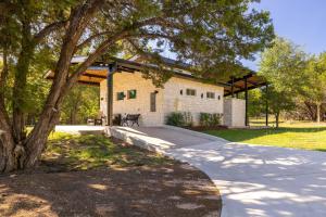 a walkway in front of a house with a tree at New Casita in Deer Creek Area in Dripping Springs