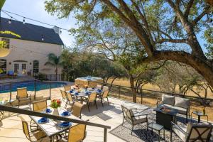 a patio with a table and chairs next to a pool at Modern Farmhouse with Private Pool in Dripping Springs
