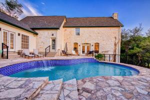 a swimming pool in front of a house at Modern Farmhouse with Private Pool in Dripping Springs