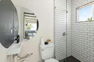 een badkamer met een toilet, een wastafel en een spiegel bij Hill Country Norwood Tiny Home A- On 13 Acres & Sleeps 2 and Pet Friendly! in Dripping Springs