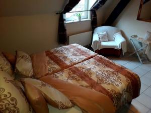 1 dormitorio con 1 cama, 1 silla y 1 ventana en Ferienwohnung für 6 Personen in Berlingen, Rheinland-Pfalz en Berlingen