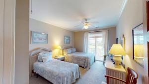 a bedroom with two beds and a table with a lamp at Golf and Beach: 2BR Lakeside Villa with Lake Views in Pawleys Island