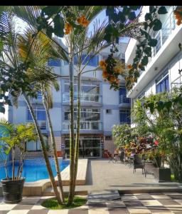 une cour avec des palmiers et une piscine dans l'établissement GRAN HOTEL VILLA DEL SUR, à San Vicente de Cañete