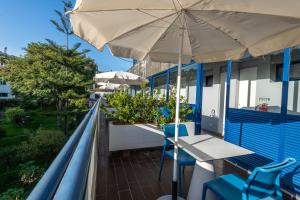 uma varanda com uma mesa e um guarda-chuva em Terrace Mar Suite Hotel no Funchal