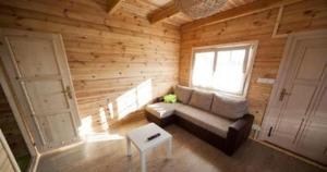 ein Wohnzimmer mit einem Sofa und einem Fenster in der Unterkunft Appartements Piaskowy Raj in Gąski