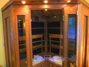 einem Holzschrank mit Glastüren in einem Zimmer in der Unterkunft Luxusfewo mit IR-Wärmekabine und Boxspringbett für Zwei in Goslar