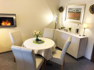ein Esszimmer mit einem Tisch, Stühlen und einem Kamin in der Unterkunft Luxusfewo mit IR-Wärmekabine und Boxspringbett für Zwei in Goslar