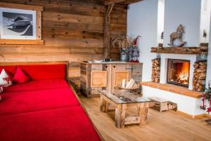 a living room with a red couch and a fireplace at Ferienhaus in Hart Im Zillertal mit Eigenem Balkon in Hart im Zillertal