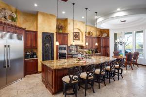 a kitchen with a large island with bar chairs at Scottsdale - 35982 N Willow Cross Dr in Cave Creek