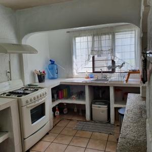 een keuken met een wit fornuis en een wastafel bij Warrior Burgos in Emiliano Zapata