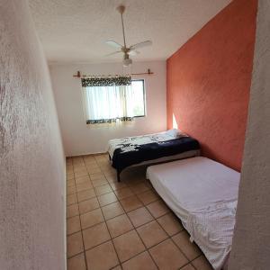 een slaapkamer met 2 bedden en een plafondventilator bij Warrior Burgos in Emiliano Zapata