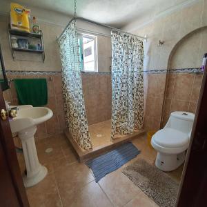 een badkamer met een douche, een toilet en een wastafel bij Warrior Burgos in Emiliano Zapata