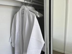a white robe hanging on a rack in a closet at Super Cute room in Architectural Home in Palm Springs
