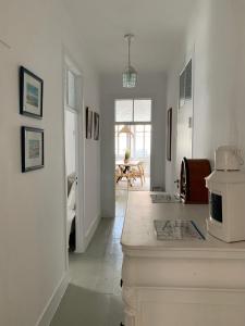 a white room with a kitchen and a living room at Central Ericeira 4 Bedrooms by Lovely Bay - Fte Cabo in Ericeira