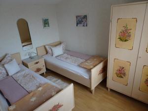 ein kleines Zimmer mit 2 Betten und einem Sofa in der Unterkunft Kleines Ferienhaus im Garten- Haus Holzheimer mit dem einzigartigen Blick über Bad Kissingen bis zur Rhön in Bad Kissingen