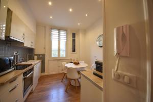 uma cozinha com uma pequena mesa e um frigorífico branco em 4P Terrasse, Palais à 500 m, Charme Bourgeois em Cannes