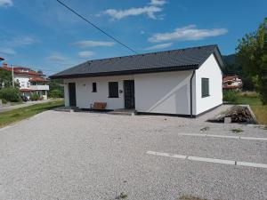 una pequeña casa blanca con un aparcamiento de grava en Dantin guest house en Prvačina