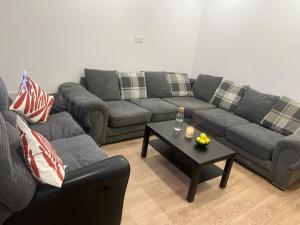 En-suit double bedroom with bathroom in Manchester في مانشستر: غرفة معيشة مع أريكة وطاولة قهوة