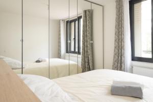 a bedroom with two beds and a mirror at Le Berceau ~ T2 Spacieux ~ Proche Paris & RER A in Nogent-sur-Marne