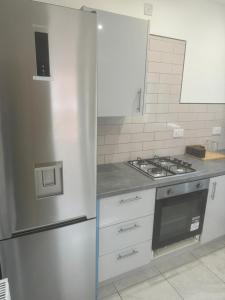 a kitchen with a stainless steel refrigerator and a stove at En-suit double bedroom with bathroom in Manchester in Manchester