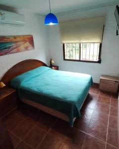 um quarto com uma cama com um edredão verde em Hermosa casa, jacuzzi climatizado em Bella Vista