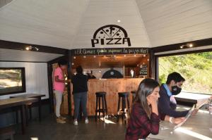 een groep mensen die rond een bar in een restaurant staan bij Terra Luna Lodge in Puerto Guadal