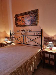 a bed in a bedroom with two nightstands and two lamps at Elìsim House in Caiazzo