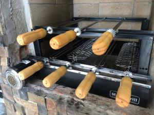 Ein Haufen Hot Dogs, die auf einem Grill kochen. in der Unterkunft Edícula/Casa de hóspedes: 3 dorms 3 banheiros, piscina 7x5, churrasqueira, 150m do mar in Mongaguá