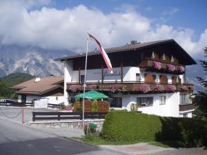 ein Gebäude mit einer Flagge und Blumen davor in der Unterkunft Gästehaus Fernblick in Sautens