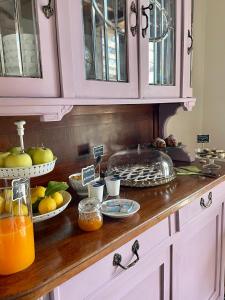 una encimera de cocina con fruta y zumo. en Casale dell'Assiolo Bed and Breakfast, en Petrignano sul Lago