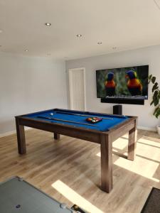a ping pong table in a living room at Detached Flat in Leeds, Free WIFI and parking, Pool table, 75 inch tv, Netflix, Disney plus in Moortown