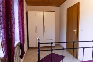 ein Schlafzimmer mit einem Bett, einem Schrank und einer Tür in der Unterkunft Ferienwohnung auf einem Reiterhof in Weißenstadt
