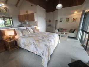 a bedroom with a bed and a living room at Muri Retreat Apartments in Rarotonga