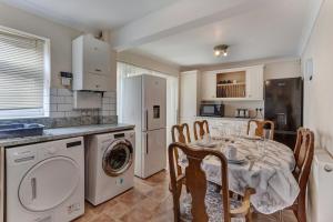 - une cuisine avec une table et un lave-linge/sèche-linge dans l'établissement Spacious & Centrally Located Home in Basildon With Parking Close to Town Centre, à Basildon