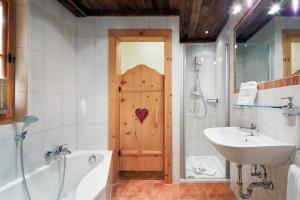 Ferienhaus für vier Erwachsene und zwei Kinder mit Sauna und Kamin في فلاخاو: حمام مع حوض ومغسلة وباب