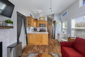 a living room with a red couch and a kitchen at Sweet Dove Cottage has Walking Trails with Fishing Pond fun place to stay and play in Emory