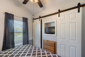 a bedroom with a sliding barn door with a tv at Sweet Dove Cottage has Walking Trails with Fishing Pond fun place to stay and play in Emory