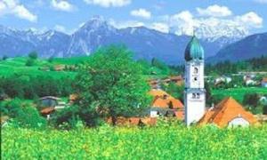 une tour blanche avec un sommet vert dans un village dans l'établissement Gästehaus Kerpf incl KönigsCard, à Nesselwang