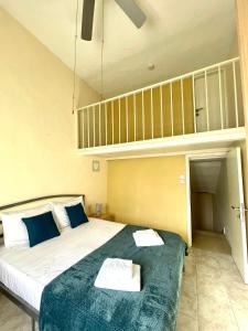 ein Schlafzimmer mit einem großen Bett mit blauen Kissen in der Unterkunft Beach House - Seaview Holiday Home in Marsalforn