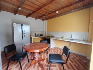 een keuken met een tafel en stoelen in een kamer bij OCALA HOUSE 4.0 in Huánuco