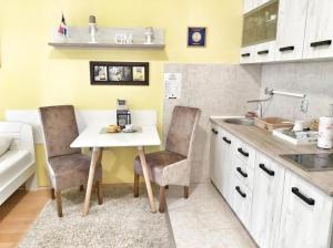 a kitchen with a table and two chairs and a sink at Yellow Diamond in Niš