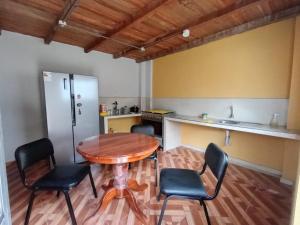 een keuken met een tafel en stoelen in een kamer bij OCALA HOUSE 4.0 in Huánuco