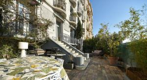 um pátio com uma mesa e cadeiras em frente a um edifício em 4P Terrasse, Palais à 500 m, Charme Bourgeois em Cannes